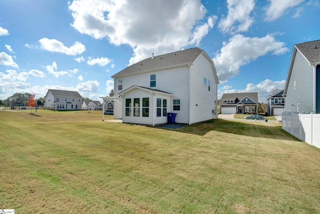 back of property with a garage and a lawn