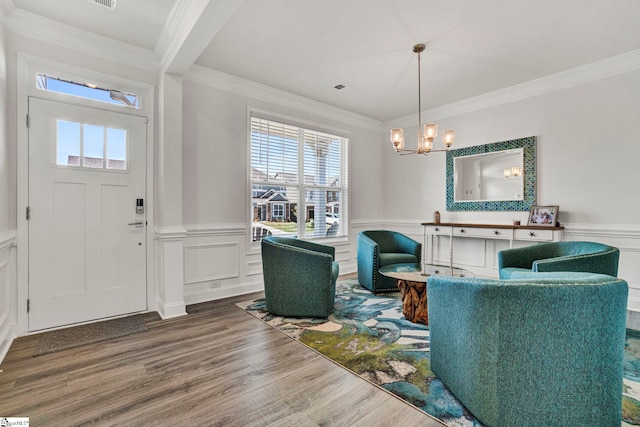 entryway featuring ornamental molding, an inviting chandelier, and hardwood / wood-style floors