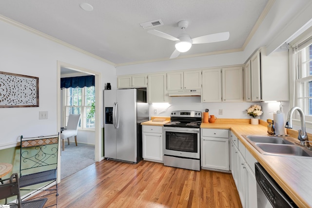 kitchen with sink, white cabinetry, stainless steel appliances, and light wood-type flooring