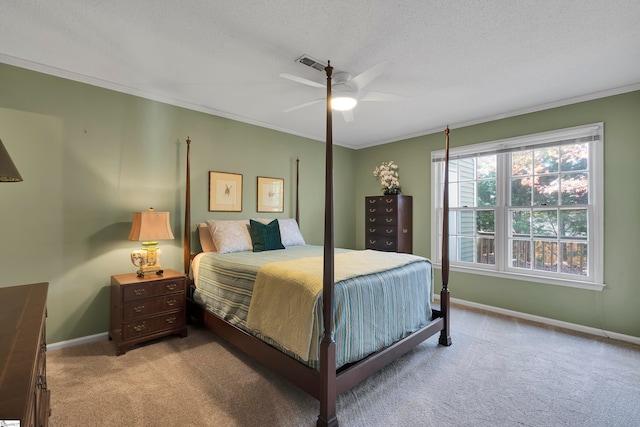 carpeted bedroom with ceiling fan, ornamental molding, and a textured ceiling