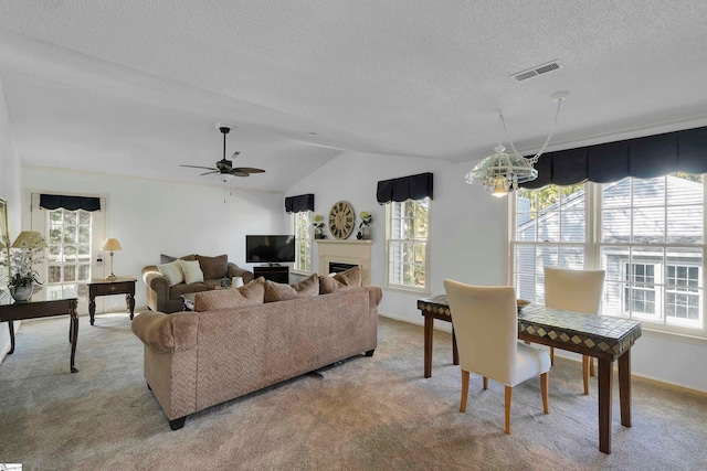 living room with lofted ceiling, a textured ceiling, light colored carpet, and ceiling fan