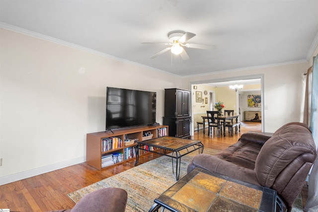 living room featuring hardwood / wood-style flooring, ornamental molding, and ceiling fan with notable chandelier