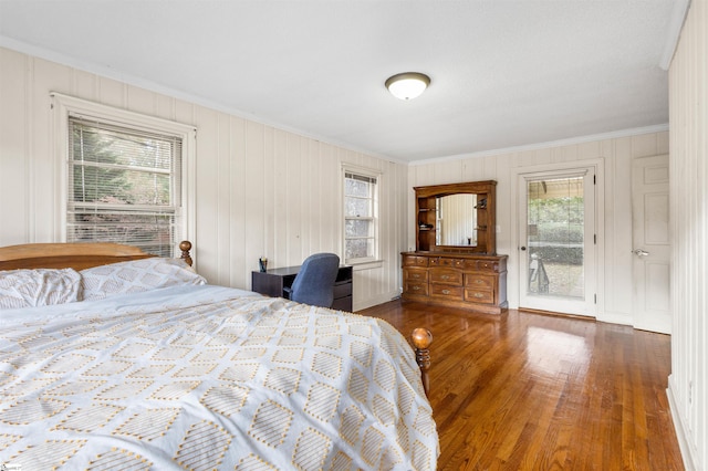 bedroom with dark wood-type flooring, crown molding, access to outside, and multiple windows