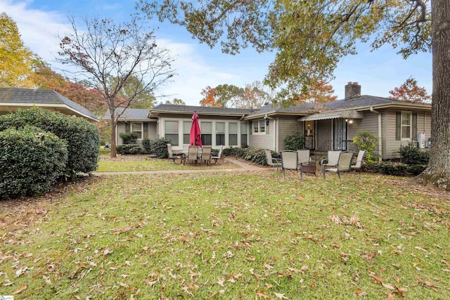 back of house with a lawn