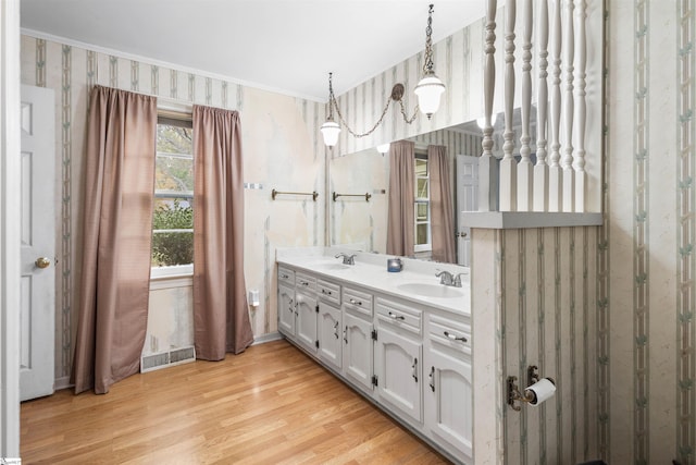 bathroom with vanity, hardwood / wood-style floors, and crown molding