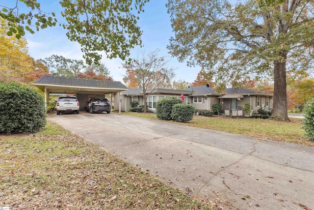 ranch-style house featuring a front lawn and a carport