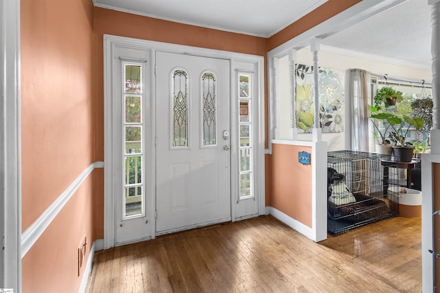 foyer featuring light hardwood / wood-style flooring and crown molding