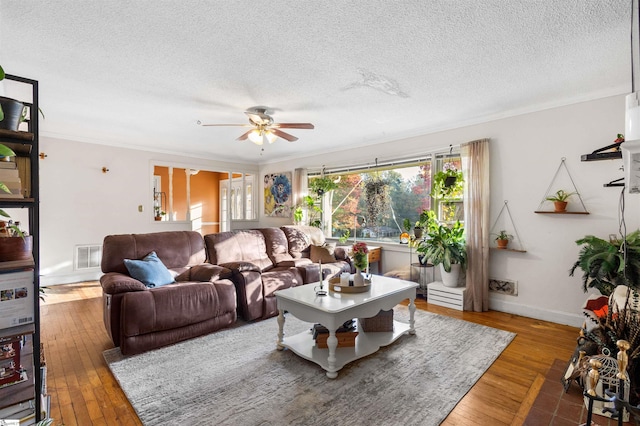 living room featuring ceiling fan, hardwood / wood-style flooring, a textured ceiling, and crown molding