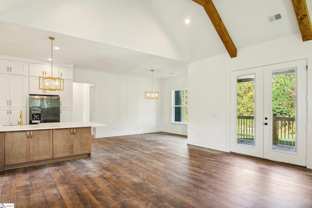 kitchen with beamed ceiling, stainless steel fridge, decorative light fixtures, and french doors