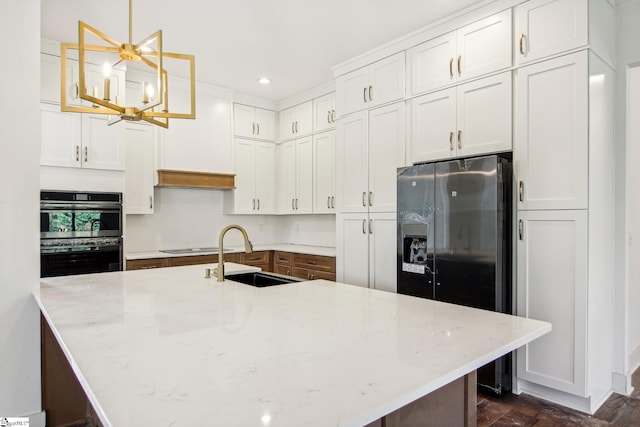 kitchen featuring light stone countertops, appliances with stainless steel finishes, sink, pendant lighting, and white cabinets