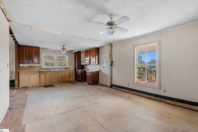 kitchen with ceiling fan, a textured ceiling, and sink