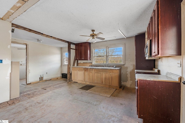 kitchen with ceiling fan, a textured ceiling, and sink