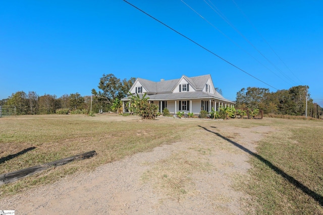 farmhouse inspired home with covered porch and a front lawn