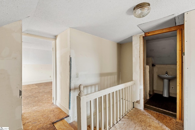 hall featuring sink, carpet, and lofted ceiling