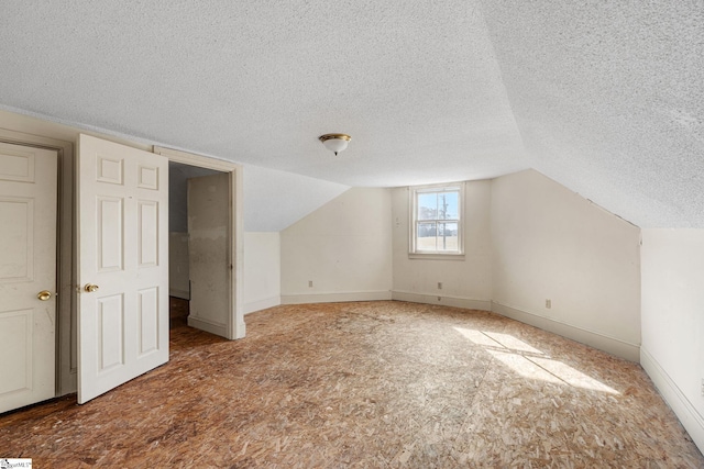 additional living space with vaulted ceiling and a textured ceiling