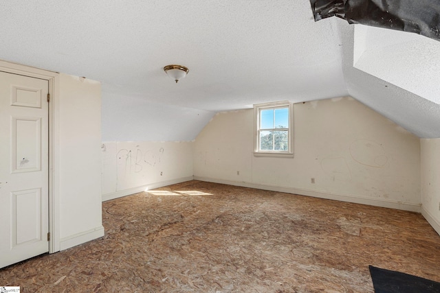 additional living space featuring lofted ceiling, a textured ceiling, and carpet floors