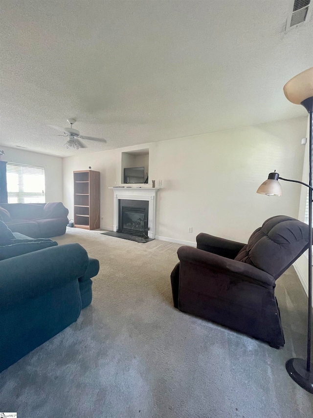 living room featuring ceiling fan, carpet, and a textured ceiling