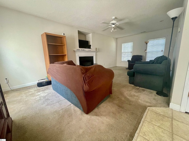 carpeted living room featuring a textured ceiling and ceiling fan