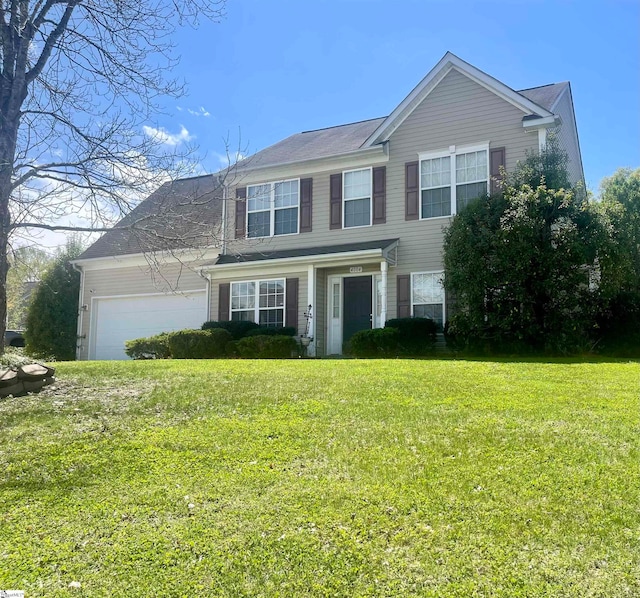 view of front of property with a front yard and a garage