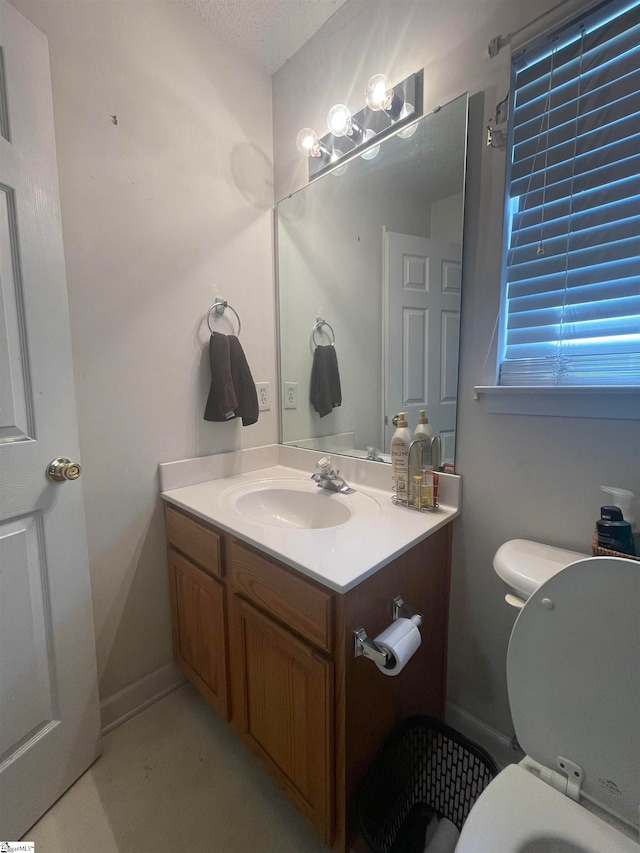 bathroom featuring vanity, toilet, and a textured ceiling