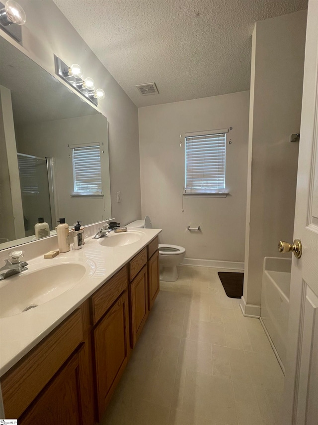 full bathroom featuring separate shower and tub, a textured ceiling, toilet, plenty of natural light, and vanity