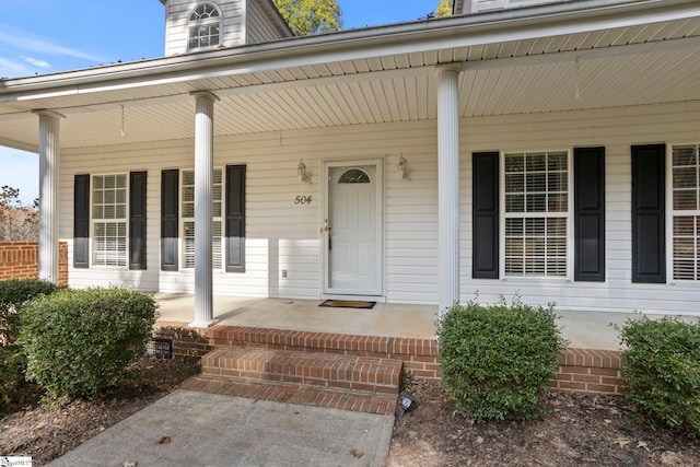 view of exterior entry featuring covered porch