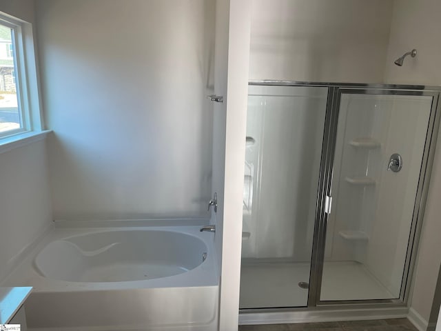 bathroom featuring separate shower and tub