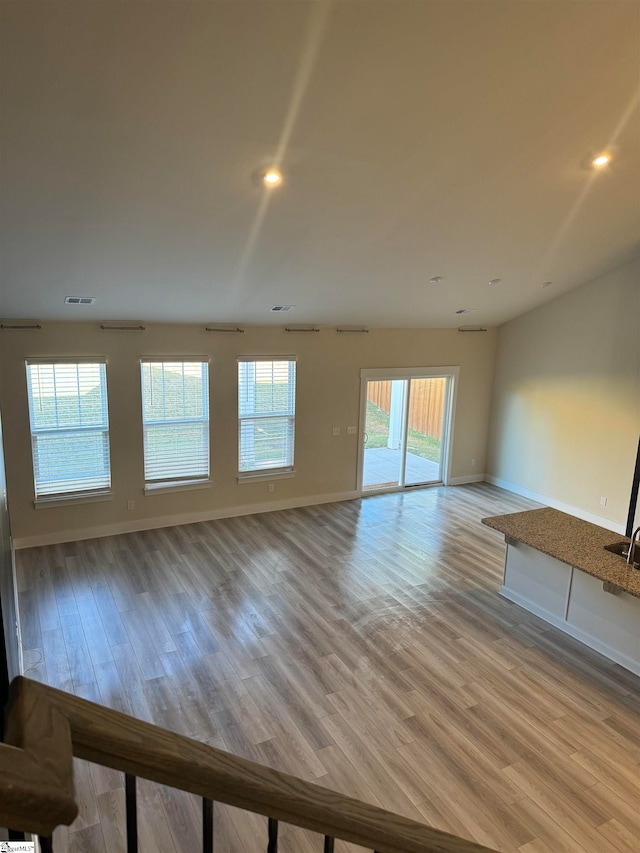 unfurnished living room featuring light wood-type flooring and a wealth of natural light