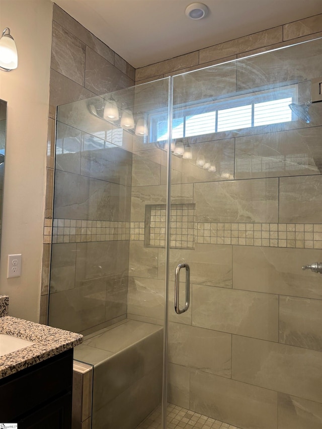 bathroom with a shower with door, vanity, and tile patterned flooring