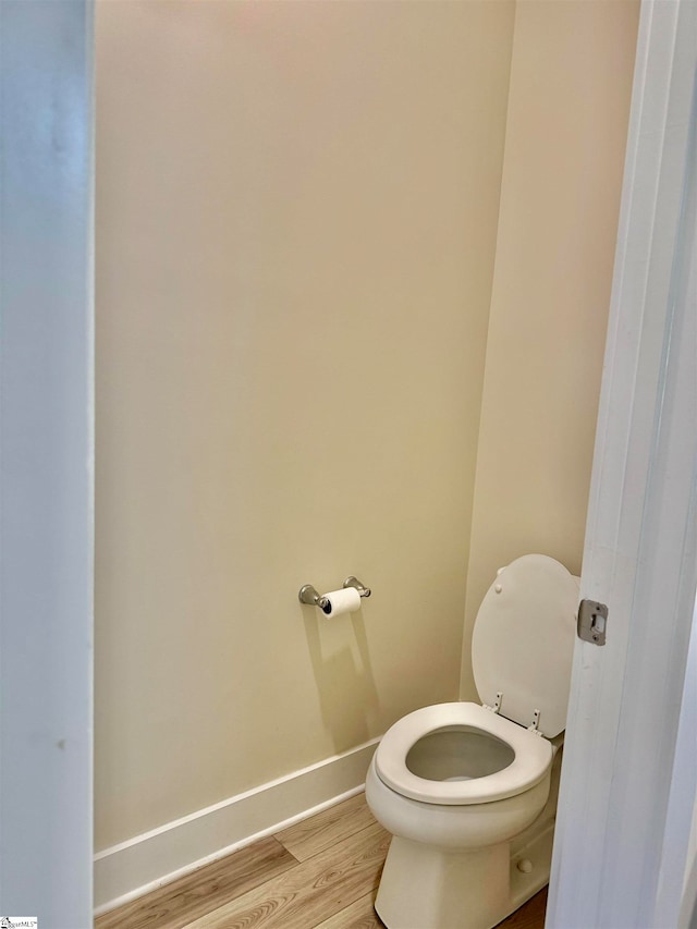 bathroom with hardwood / wood-style floors and toilet