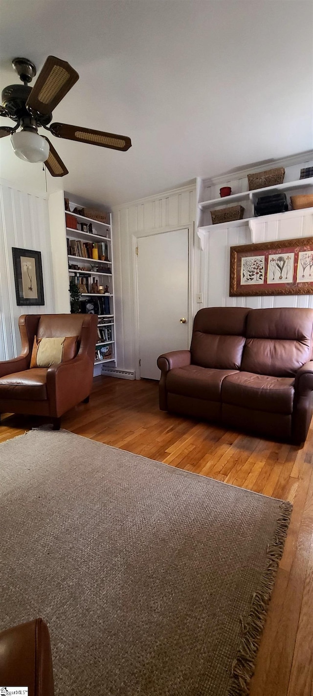 living room featuring ceiling fan, built in features, and wood-type flooring