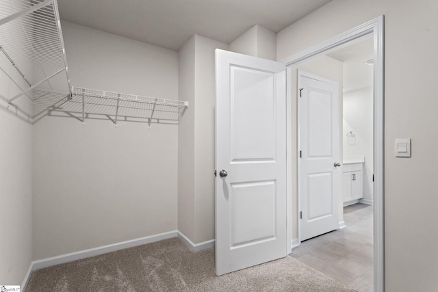 spacious closet featuring light carpet