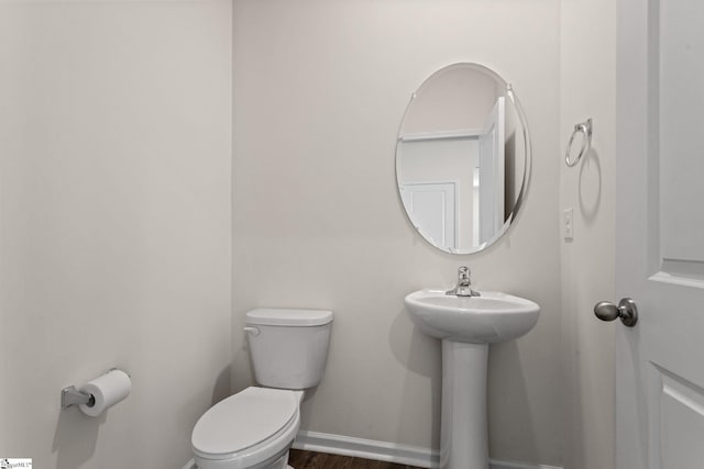 bathroom with toilet and wood-type flooring