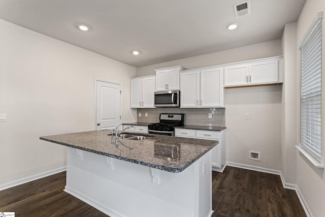 kitchen featuring dark wood-type flooring, an island with sink, sink, white cabinets, and appliances with stainless steel finishes