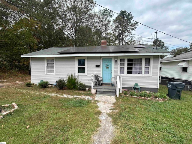 view of front of property featuring a front yard and solar panels