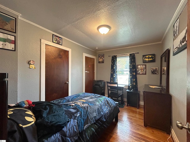 bedroom with ornamental molding, a textured ceiling, and hardwood / wood-style flooring