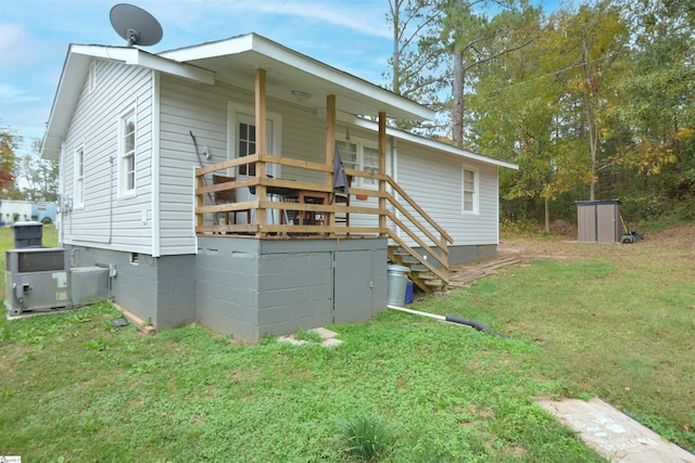 rear view of property featuring a yard and cooling unit