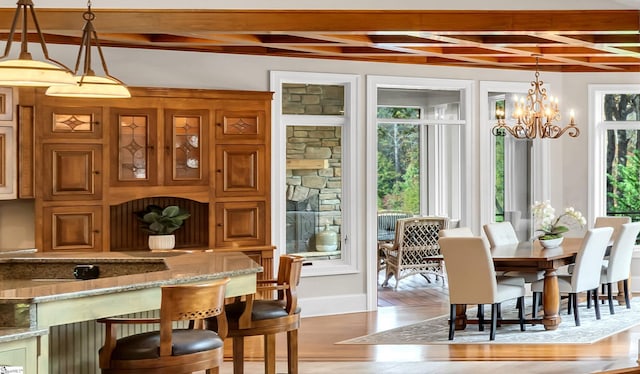 dining room featuring beam ceiling, wood-type flooring, and an inviting chandelier