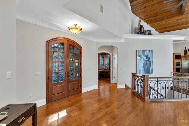 entryway featuring french doors, wood ceiling, hardwood / wood-style flooring, ornamental molding, and high vaulted ceiling