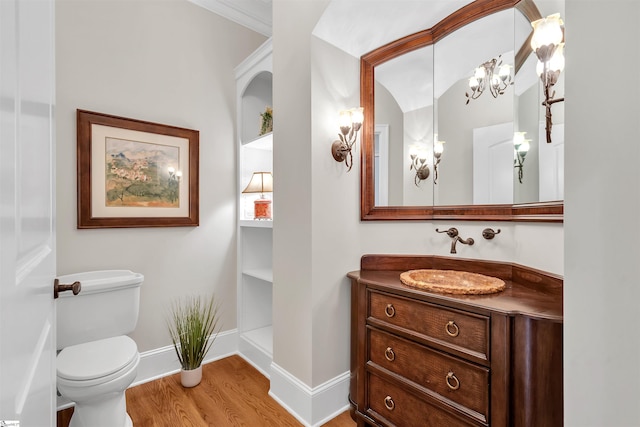 bathroom featuring vanity, toilet, hardwood / wood-style flooring, and a chandelier