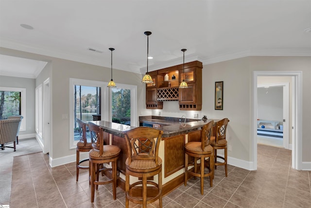 bar with a wealth of natural light, crown molding, light tile patterned flooring, and decorative light fixtures