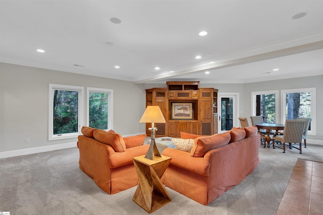 living room featuring light carpet, ornamental molding, and a wealth of natural light