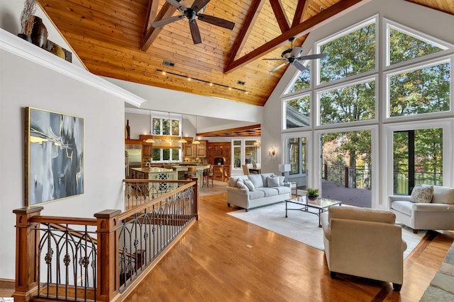 living room with a wealth of natural light, hardwood / wood-style flooring, and high vaulted ceiling