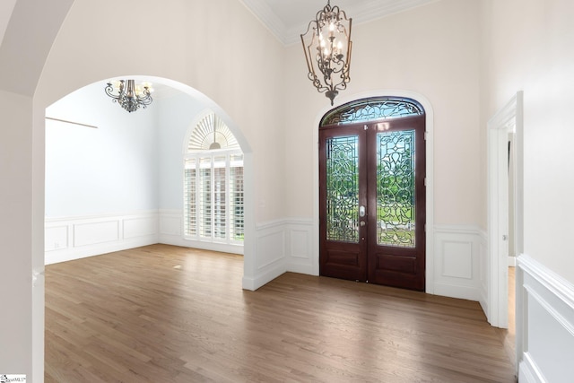 foyer with french doors, an inviting chandelier, and hardwood / wood-style floors