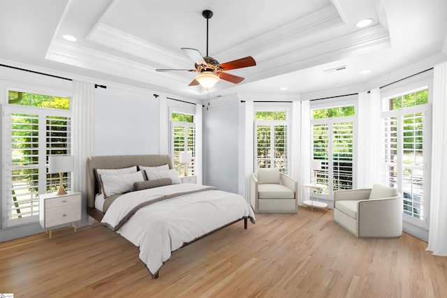 bedroom featuring light hardwood / wood-style flooring, ceiling fan, and a raised ceiling