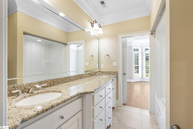 bathroom featuring vanity, crown molding, a tub, and tile patterned flooring