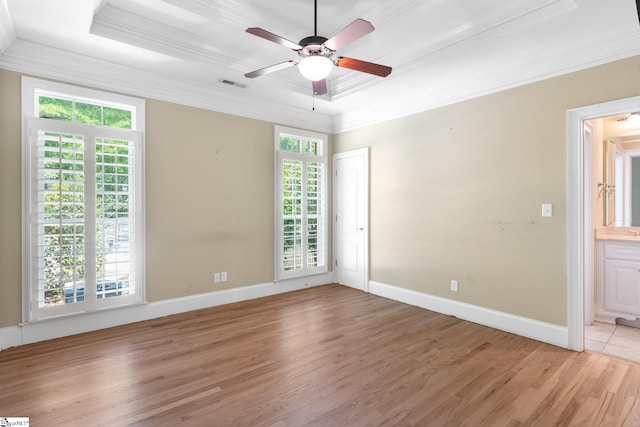 unfurnished room with light hardwood / wood-style floors, ornamental molding, a tray ceiling, and ceiling fan