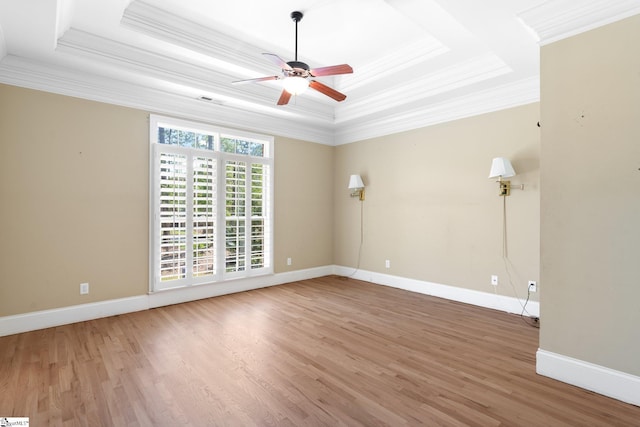 unfurnished room featuring ceiling fan, a raised ceiling, ornamental molding, and hardwood / wood-style floors