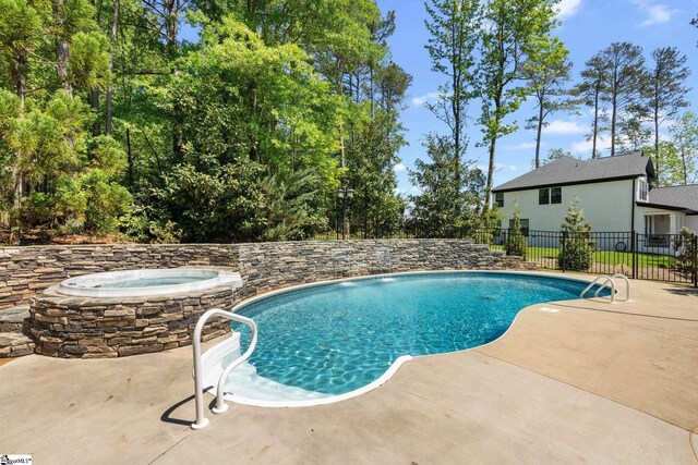 view of pool with a patio area and an in ground hot tub