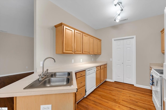 kitchen with light brown cabinets, light hardwood / wood-style flooring, kitchen peninsula, sink, and white appliances